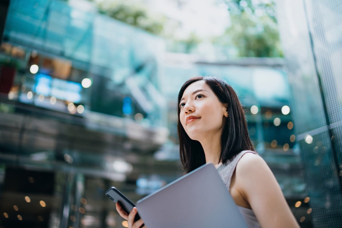 lady with laptop and phone looking pensive