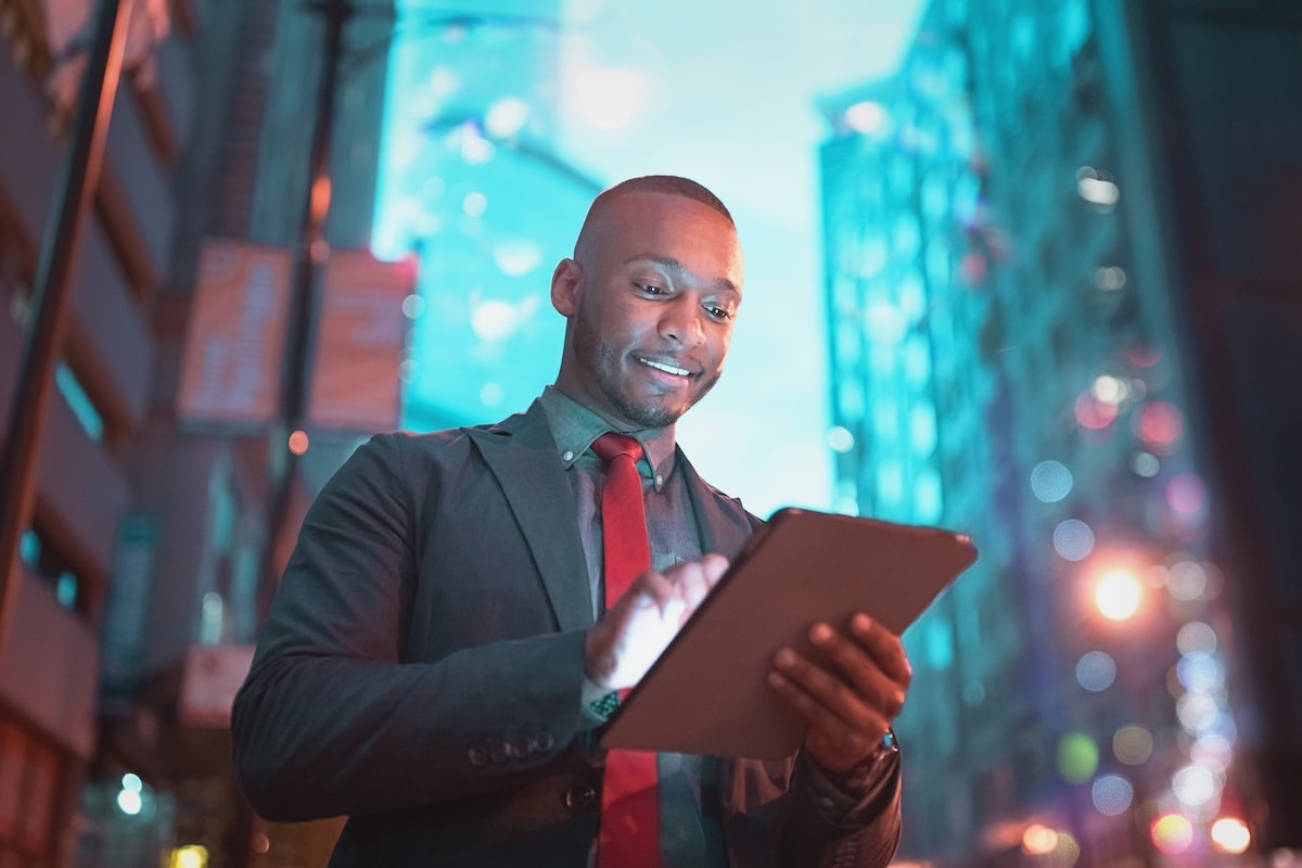 man on ipad with skyscrapers behind him