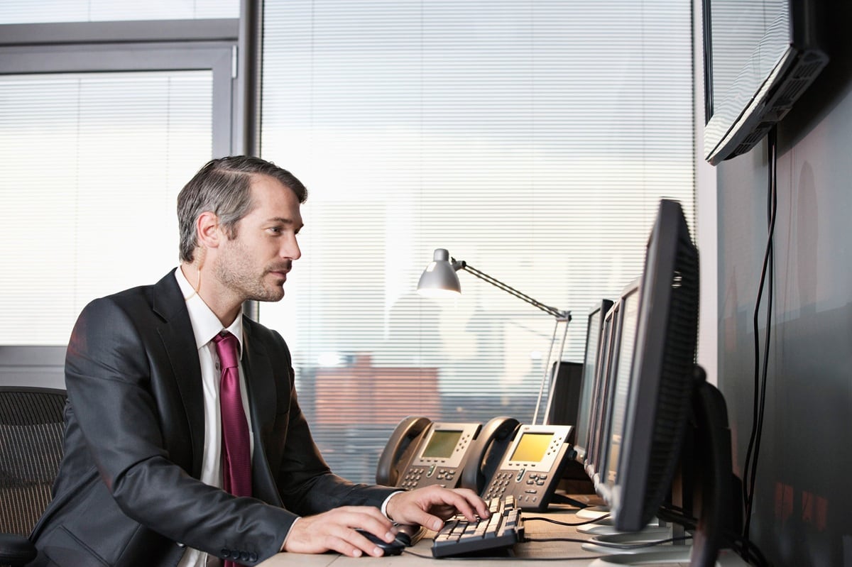 Man in office looking at screens