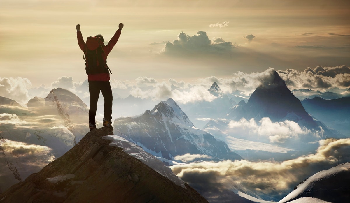Person standing at the top of a mountain 
