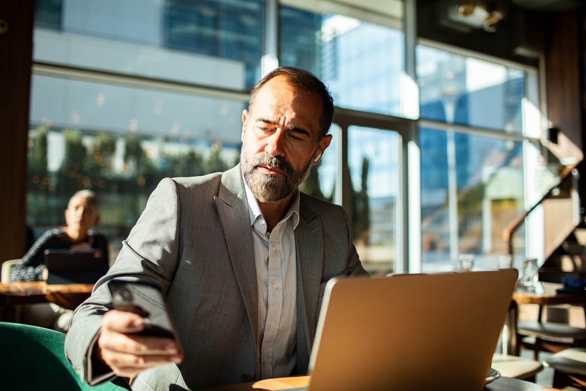 Man sitting in airport lounge looking at phone