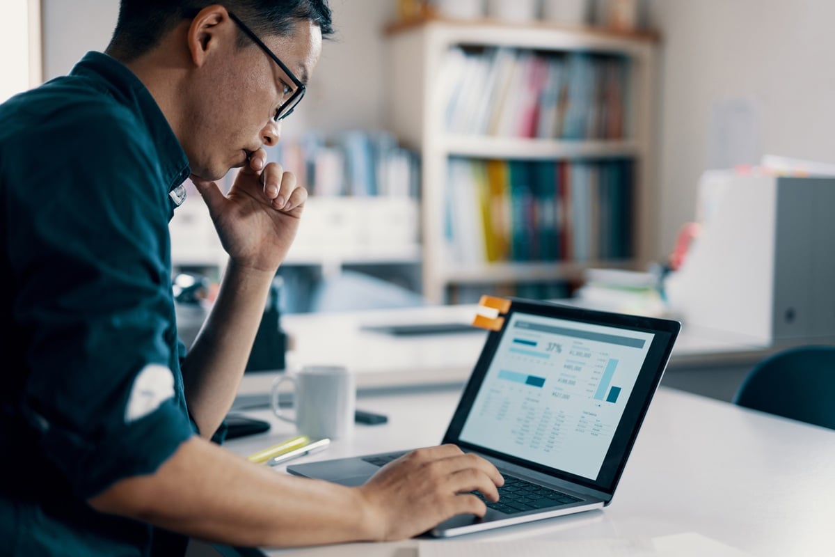 Man sitting a laptop looking at stats 