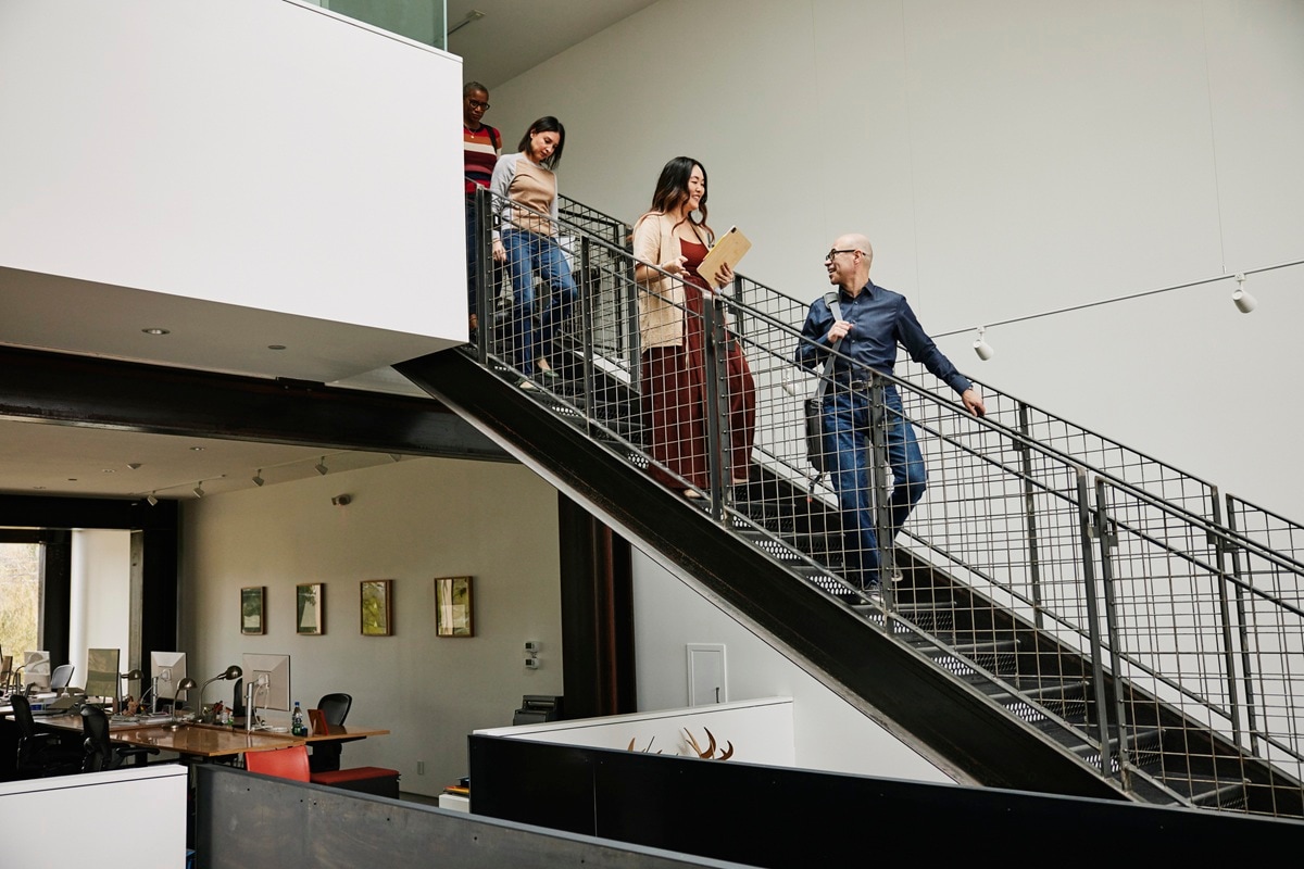 People walking down stairs in office