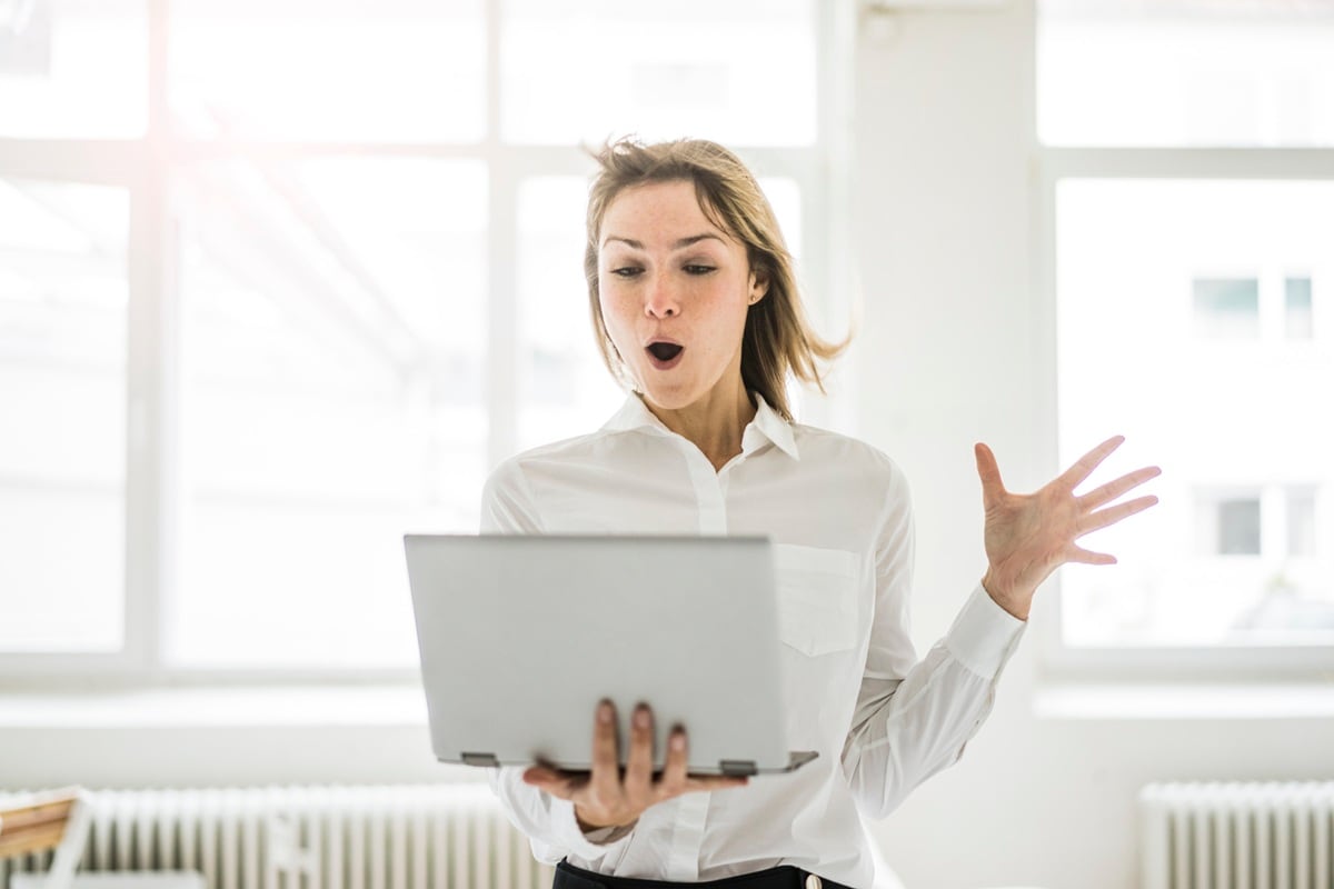 Lady standing up holding laptop