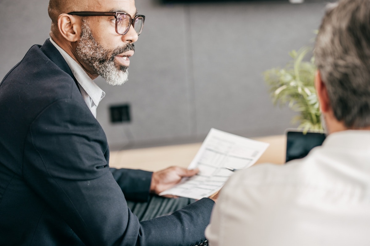 man in meeting room, wearing glasses