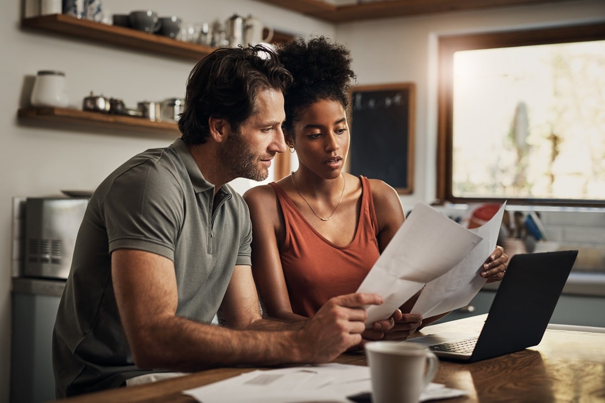 Two people looking at computer in kitchen 