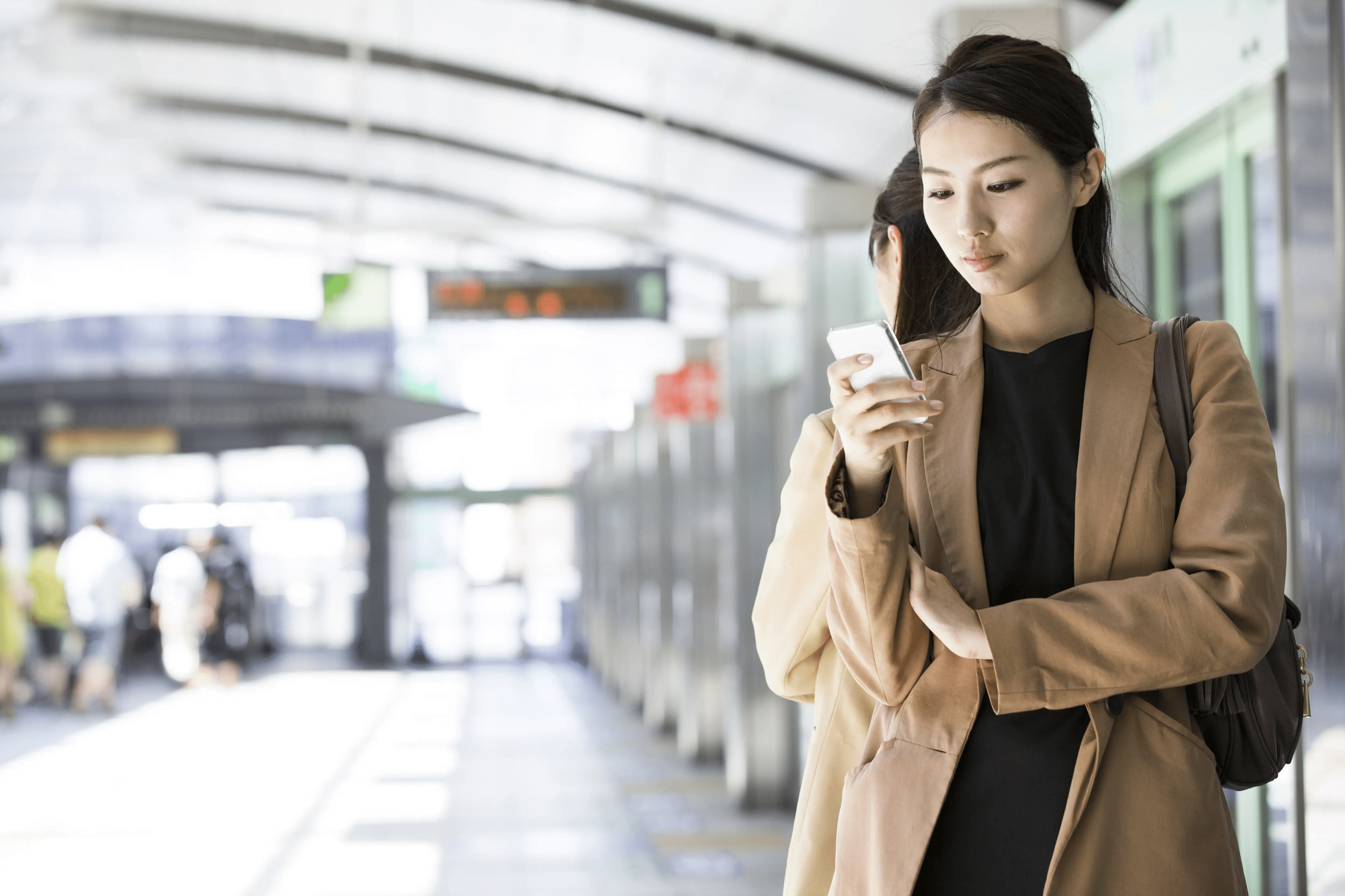 Employee looking at phone at a train station