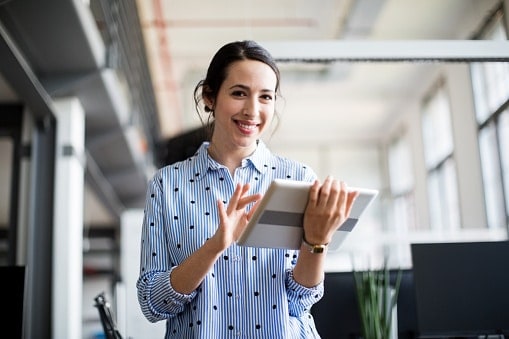 Lady in blue shirt hold tablet walking through office