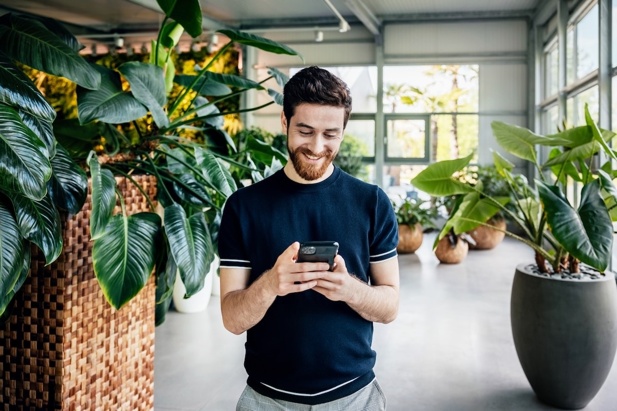 man in blue tshirt looking at phone