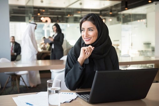 Lady in black sitting at desk with laptop open