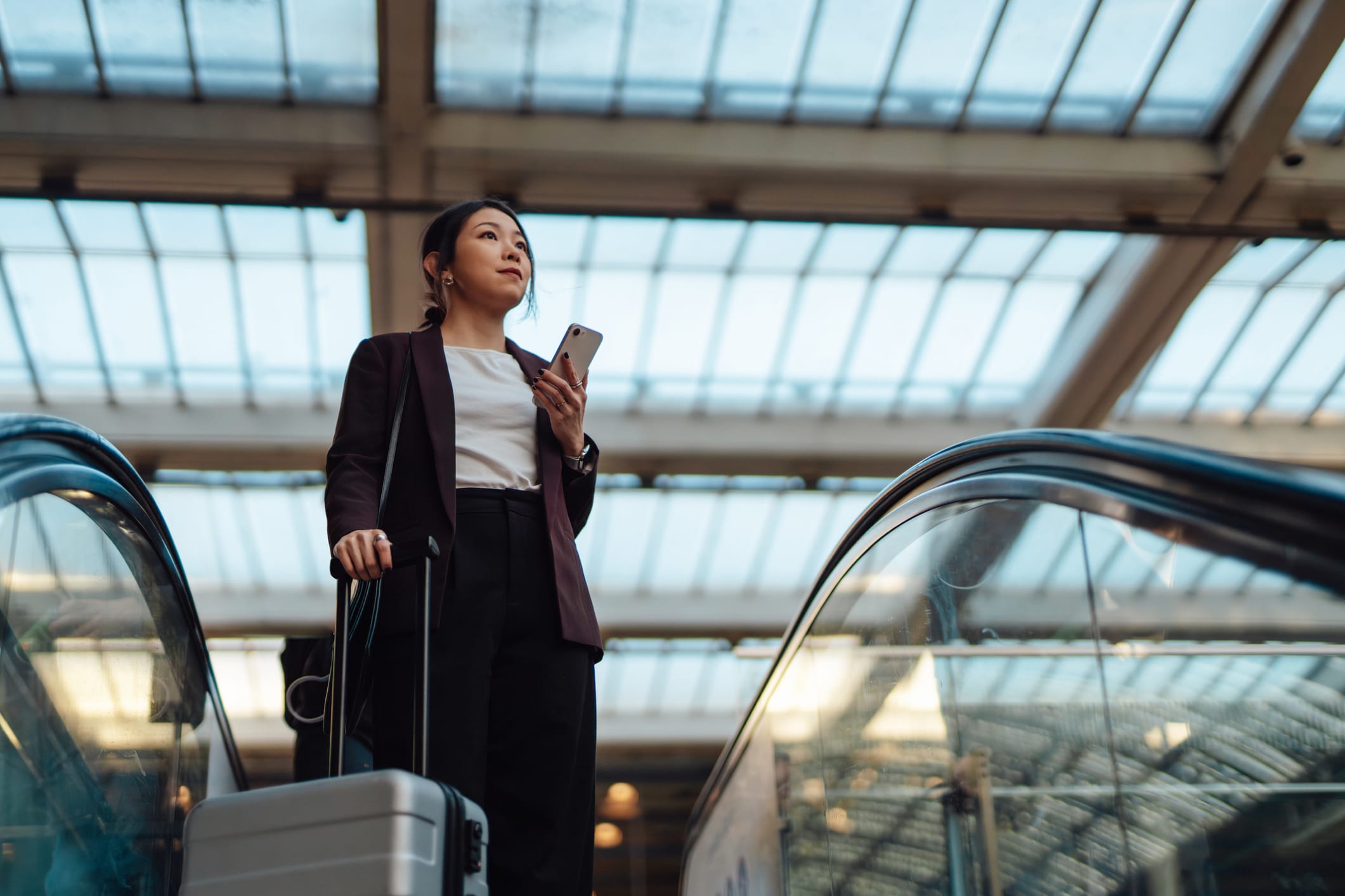 lady with suitcase on escalator