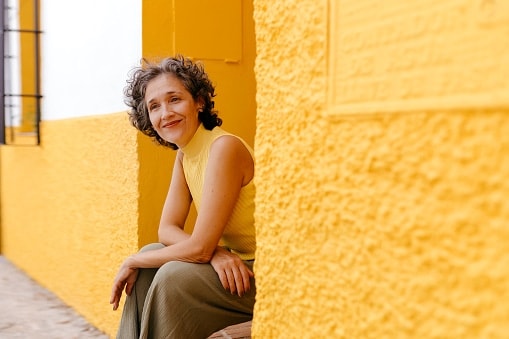 Lady in yellow top sitting in yellow doorway
