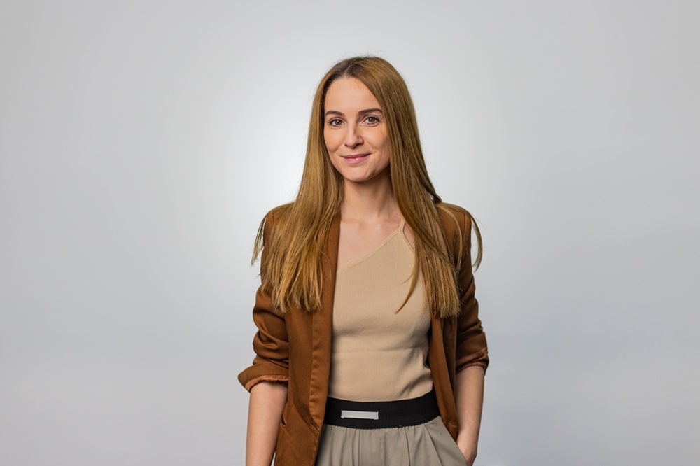 Lady with long hair in brown jacket and top 