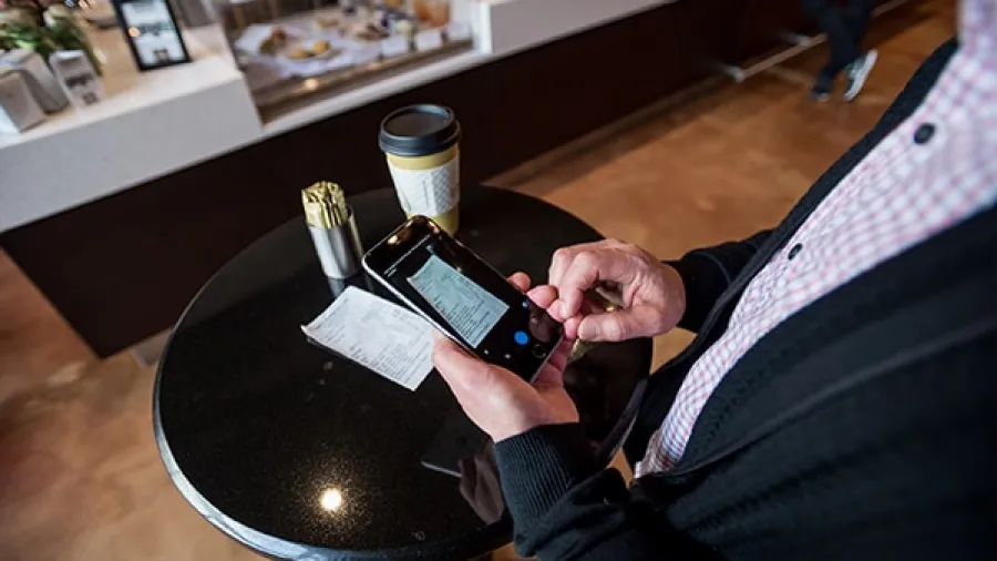 person taking picture of receipt with phone