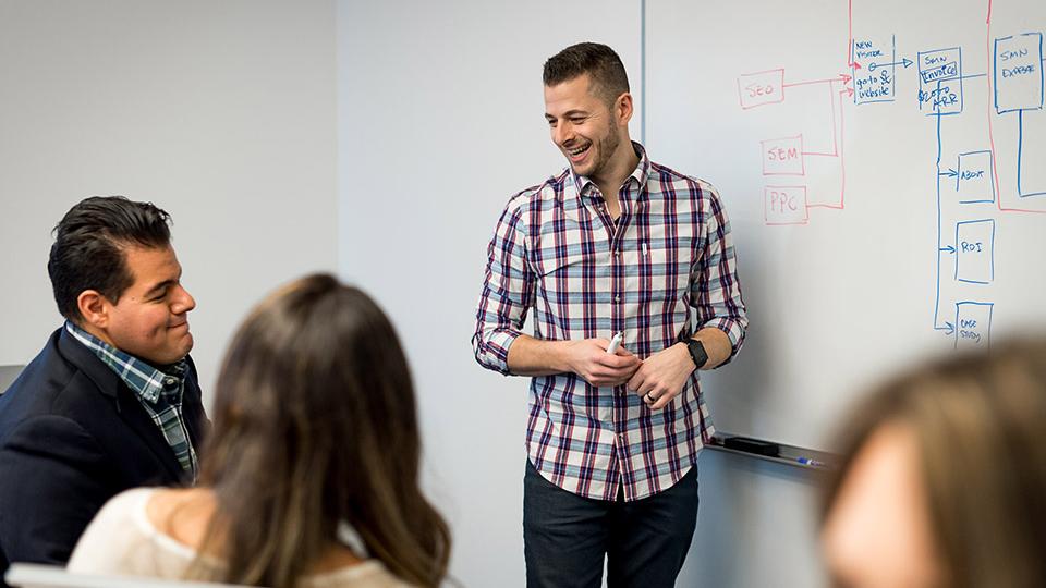 group of people working at a whiteboard