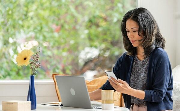 woman using phone and laptop