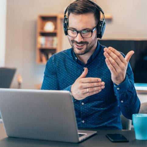 man speaking on phone and looking at laptop