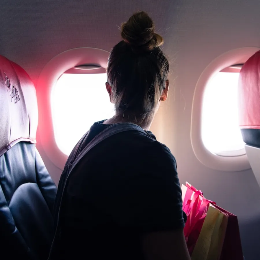 Woman looking out of a plane window