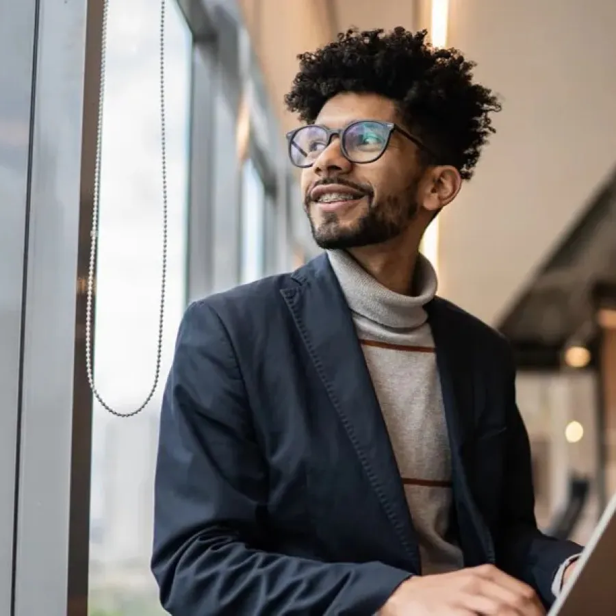 man on laptop looking out window
