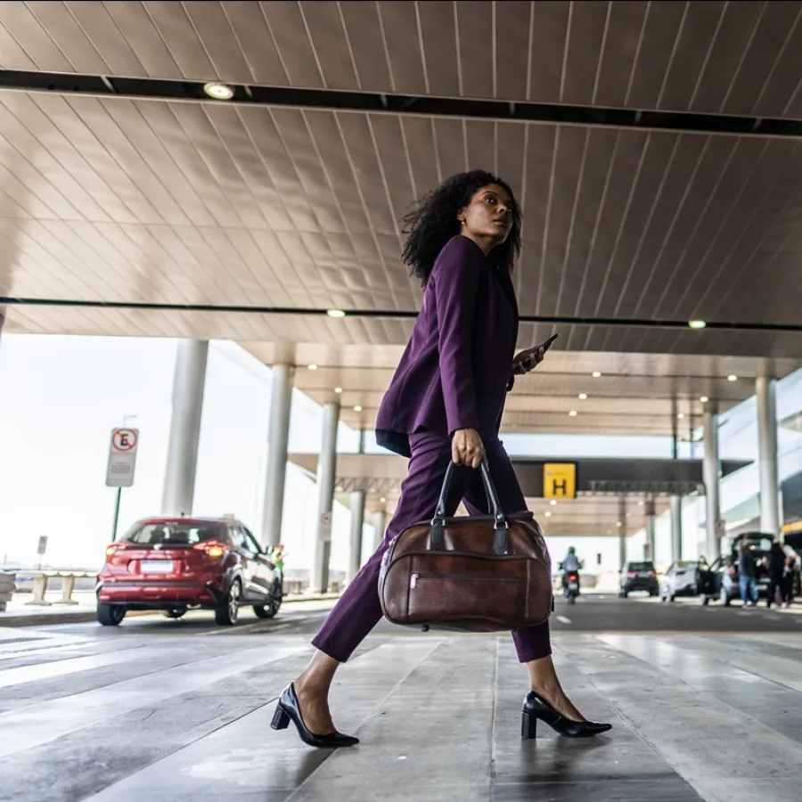 Lady with brown bag crossing road in airport