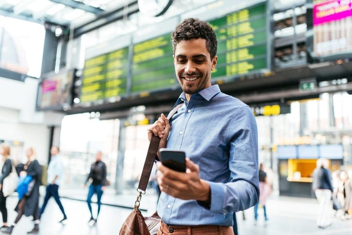 business traveller in city with mobile phone