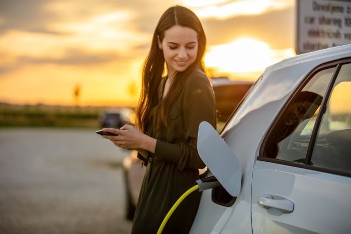 woman in green dress charging an electric car