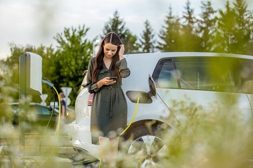 woman in green dress charging an electric car